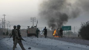 Afghan soldiers walk towards flames outside the U.S. Consulate after an attack by insurgents, in Herat province